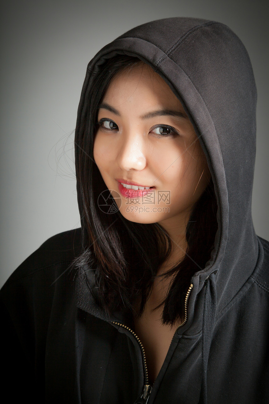 有吸引力的亚洲女孩 20岁在演播室拍摄快乐女性幸福成功帽衫黑发灰色背景喜悦冒充图片