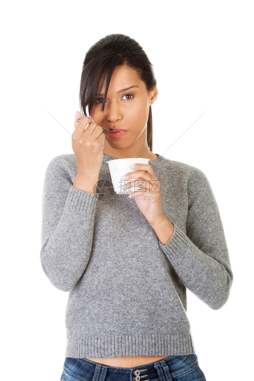 年轻女人吃酸奶作为健康的早餐或零食产品黑发喜悦女孩小吃食物饮食工作室成人混血儿图片