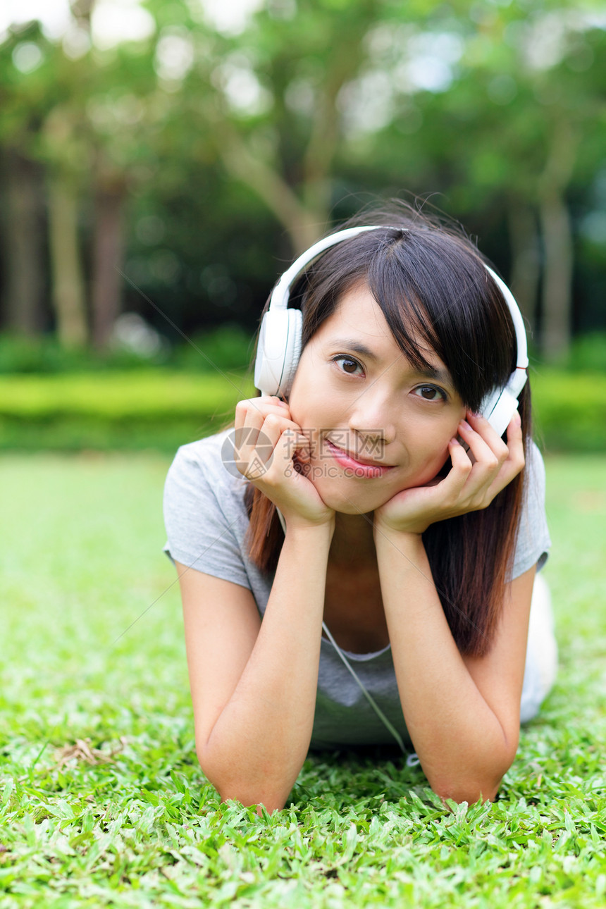 亚洲女人听草地上的歌耳机音乐女士歌曲说谎图片