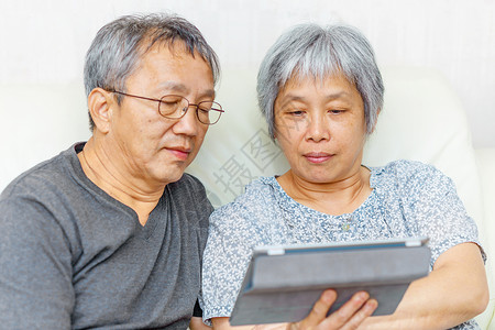 亚洲老年夫妇白色头发夫妻女性灰色电脑两个人老夫妻药片家庭背景图片