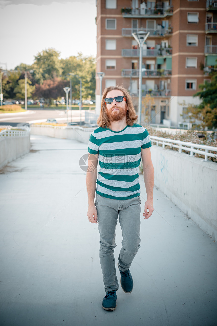 具有长长红色头发和胡须生活方式的时时时时流行模式冒充男性胡子城市街道蓝色男人太阳镜发型潮人图片