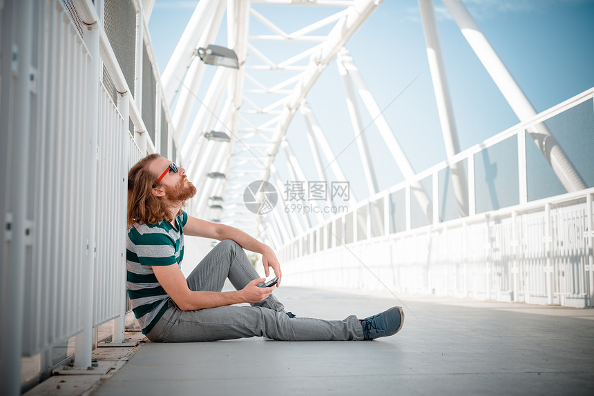 长长红头发和胡须生活方式的时时尚时装模型呼唤蓝色红色胡子沟通城市潮人电话太阳镜男性图片