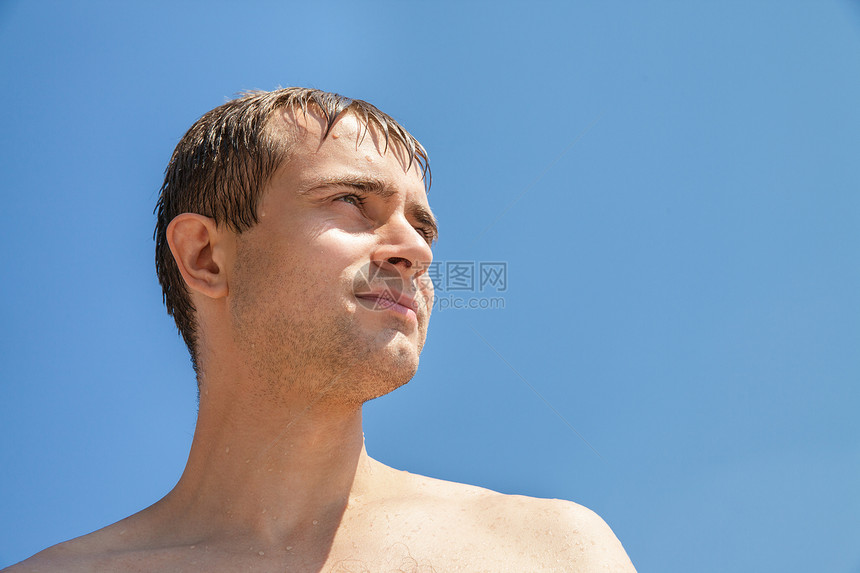 蓝色天空背景下湿润的年轻人图片