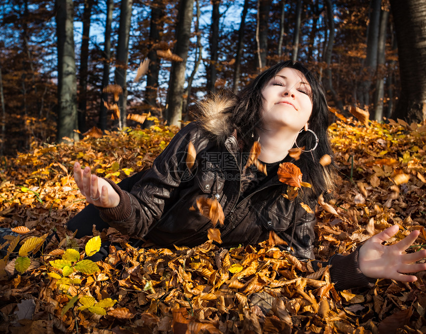 躺着落叶的年轻女子图片