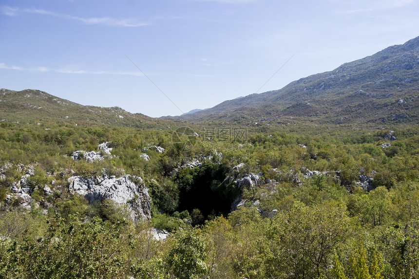 进入克罗地亚达尔马提亚山洞穴的入口雕刻顶峰隧道岩石峡谷蓝色侵蚀旅行石头荒野图片