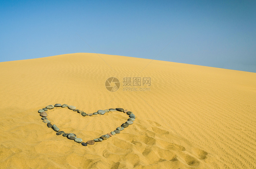 心在沙沙中海滩太阳沙粒天空波纹谷物爬坡蓝色心形假期图片