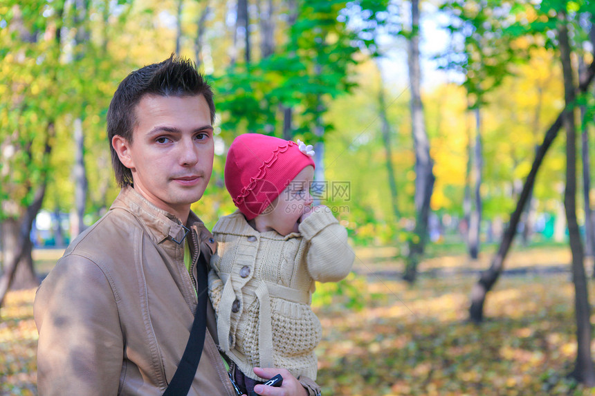 年轻父亲和她可爱的小女儿在秋天公园户外露营时散步图片