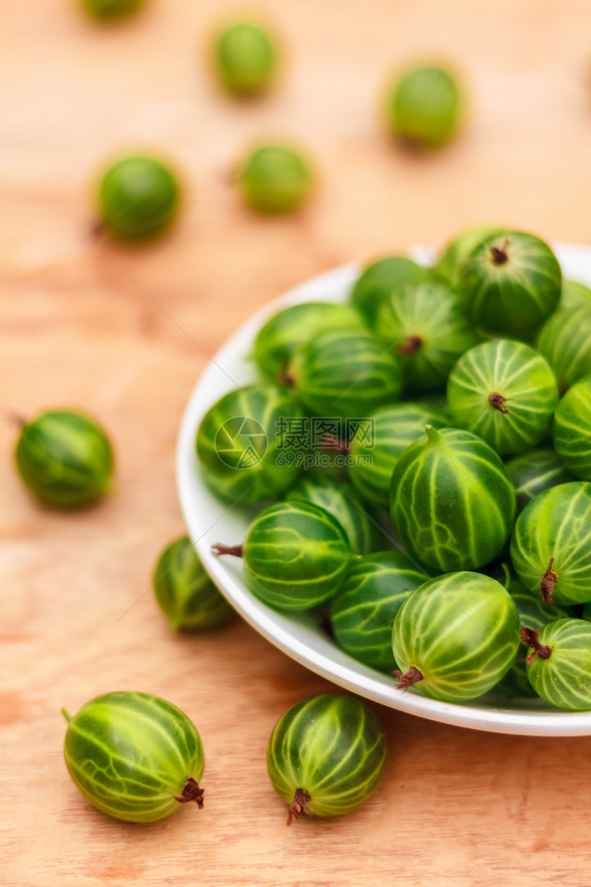 将鹅莓贴近在木质桌上的白色白菜桌盘子醋栗饮食浆果甜点水果烹饪早餐美食乡村图片