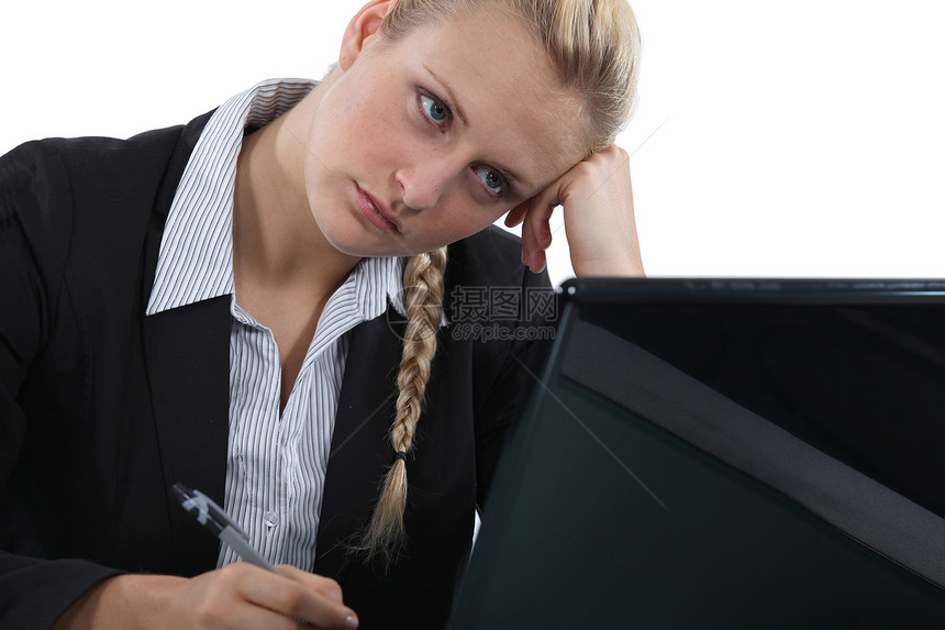Pensive办公室工作人员坐在膝上型电脑上图片