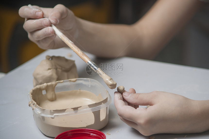女孩用泥土做玩具陶器车轮陶瓷洞察力雕塑家拇指工艺手工商品艺术家图片