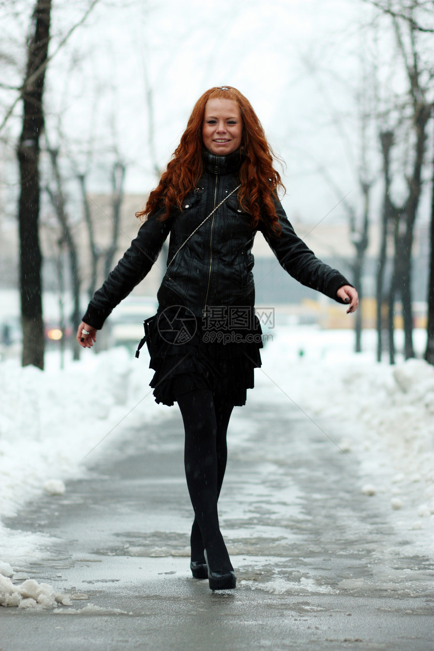 休息雪中公园的冬季妇女红发快乐幸福女孩手套头发薄片毛皮女性衣服图片