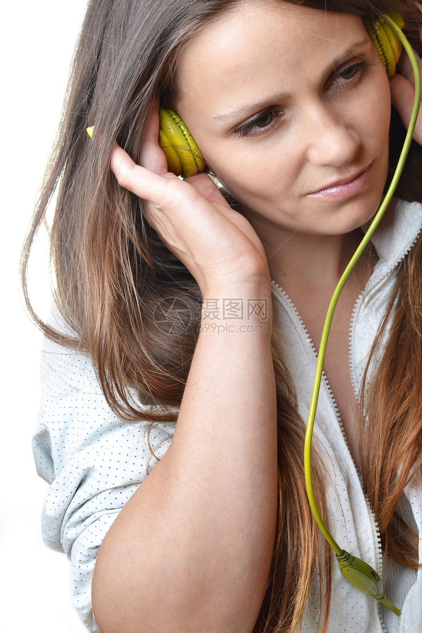 聆听音乐的美丽的年轻女士耳机白色女孩享受乐趣绿色女性黑发图片