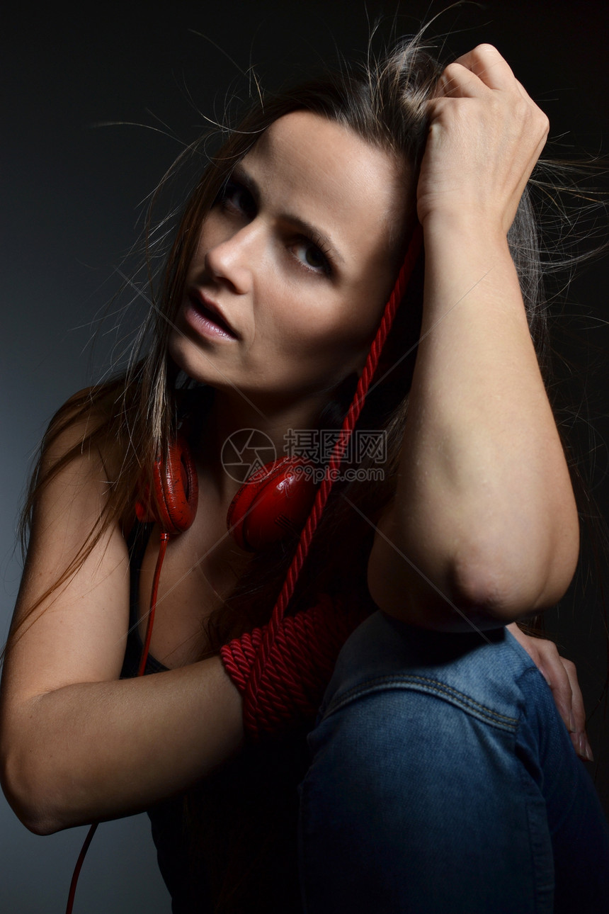 一个美丽的年轻女孩 带着红耳机背景黑发享受红色音乐黑色女性乐趣图片