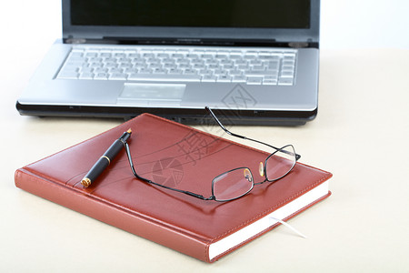 服务台上的组织者 眼镜 笔和笔记本背景图片