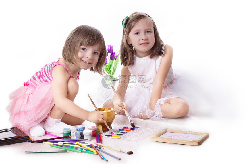 两个小女孩用油漆画画的图片