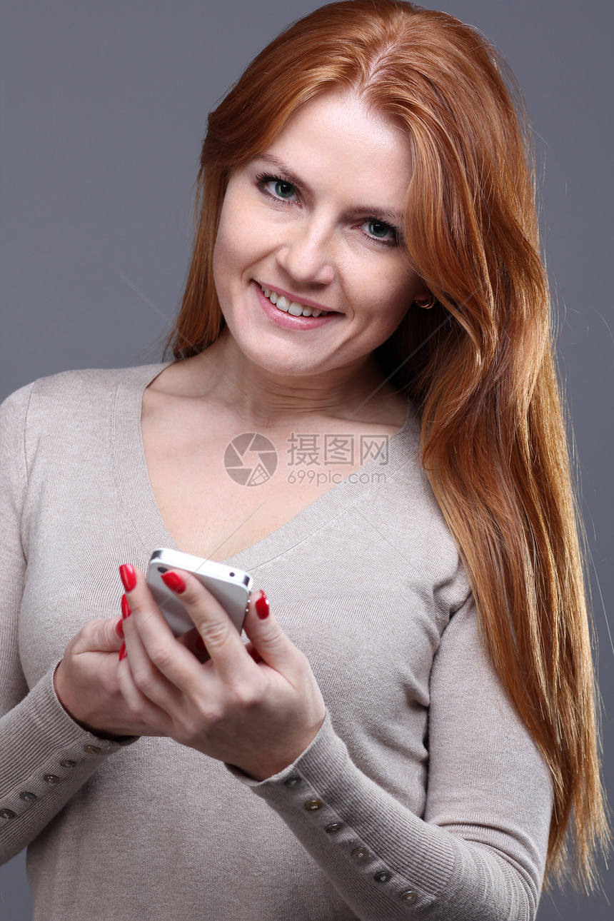 美丽的年轻女子享受女性女士喜悦技术短信红发手机女孩消息图片
