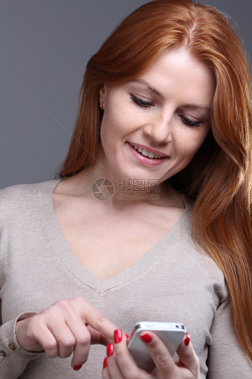 美丽的年轻女子女孩手机喜悦技术女士短信红发消息享受女性图片