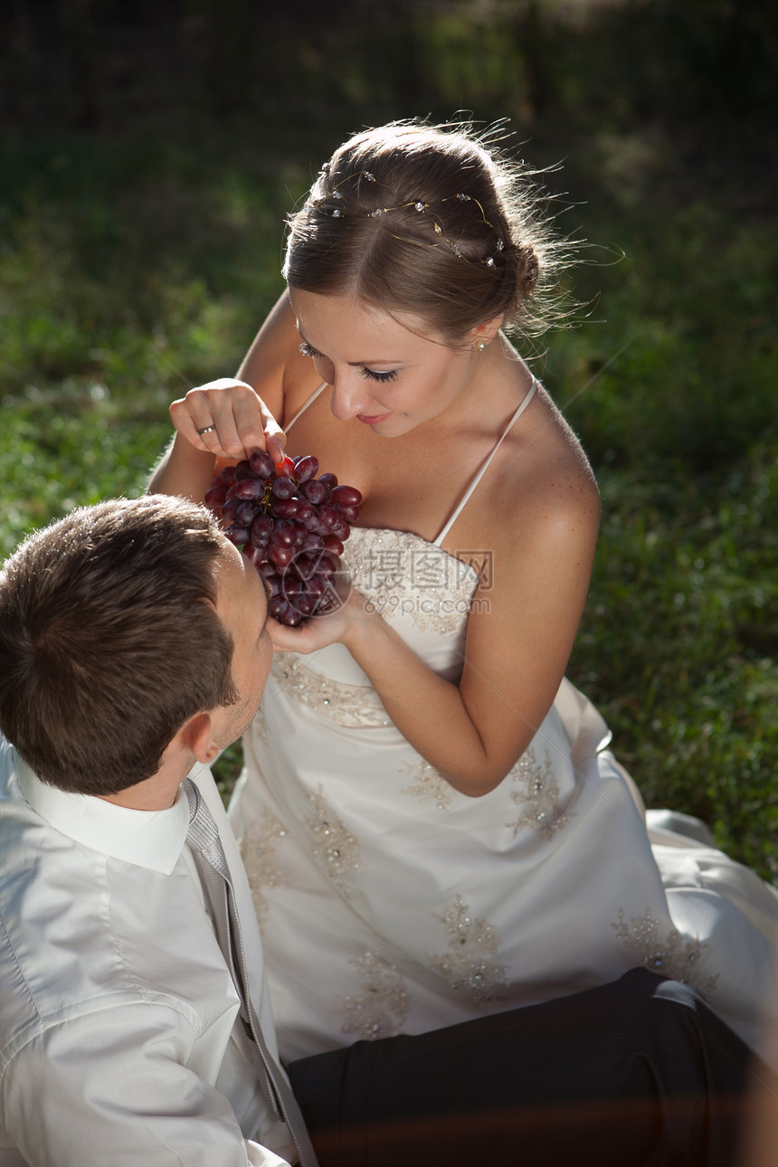 快乐的年轻夫妇婚礼女士新娘夫妻婚姻水果家庭男人裙子花束图片