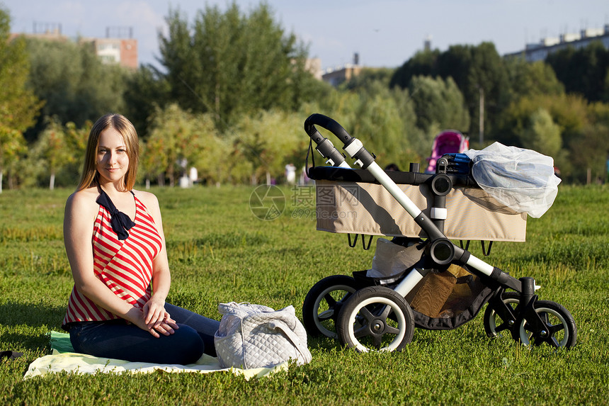 年轻母亲为新生儿带婴儿婴儿婴儿车休息男生女士孩子公园运输冒充青年姿势家庭图片