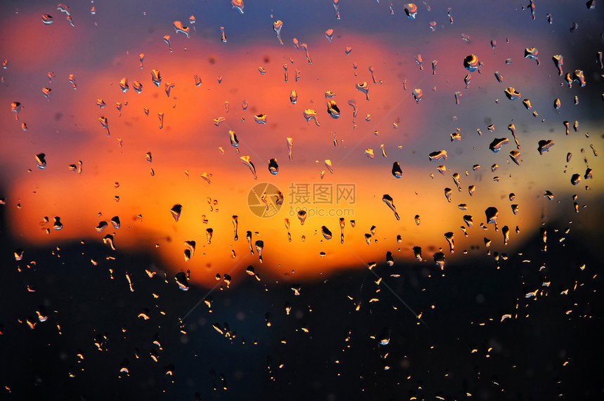 窗玻璃上滴落的克里斯托水 在美丽的夕阳下图片