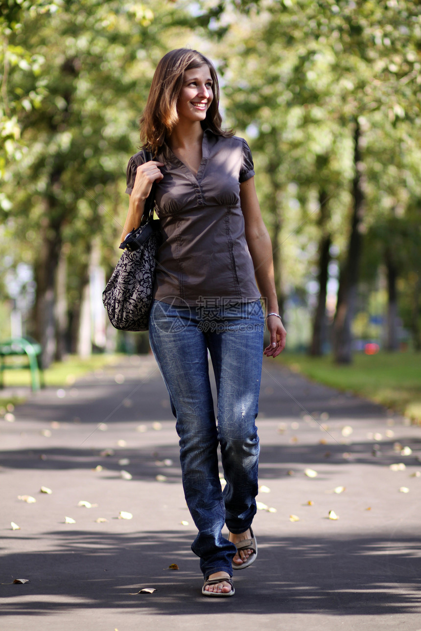 全长 在秋天公园散步的女人天气休息皮肤微笑公园女士小路树木黑发衣服图片