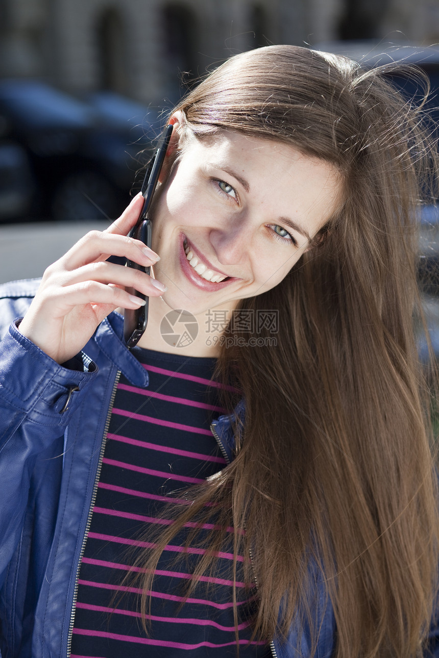 快乐的女子在手机上聊天黑发女性女士幸福微笑成人街道女孩白色青年图片