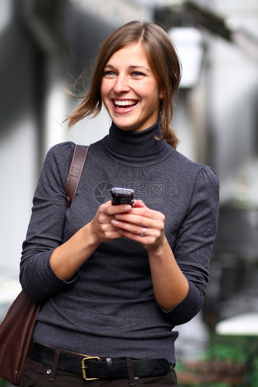 快乐的女子在手机上聊天黑发青年女士幸福女孩白色街道讲话女性细胞图片