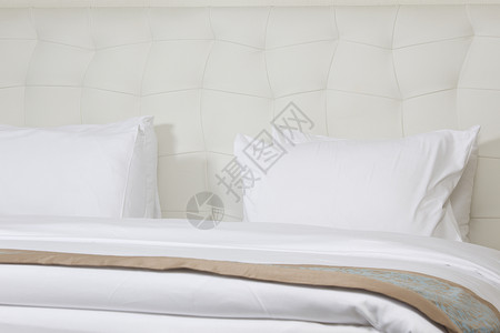 在豪华酒店房间的国王大床奢华假期水平枕头商业床头板木头墙纸套房陈列柜背景图片