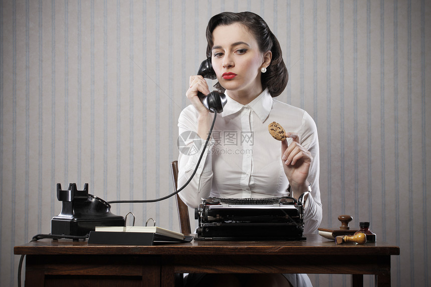 妇女通过电话在办公桌上聊天打字机女子办公室成人小吃风格水平旋转人士秘书图片