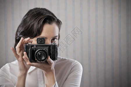 拿着旧相机的女人背景图片