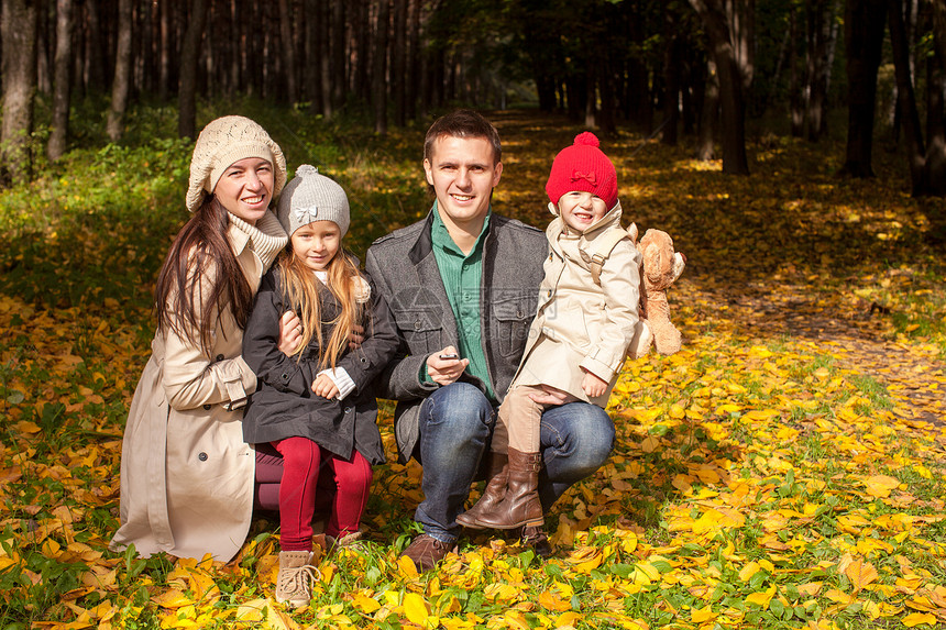 可爱的四口人家庭 在公园享受阳光明媚的秋天女儿母性乐趣父亲树木女孩父母姐姐树叶幸福图片