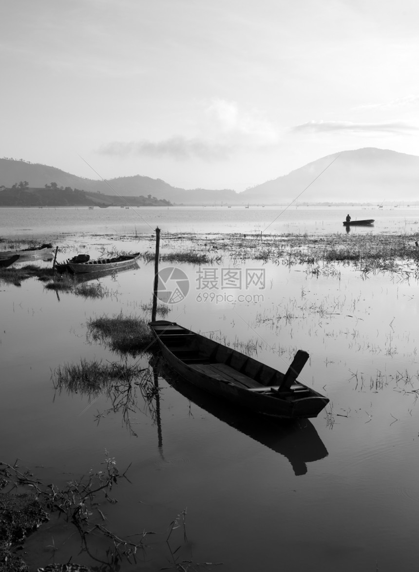 渔民在宁静湖上划船旅行工作地表钓鱼场景国家反射村庄孤独渔船图片