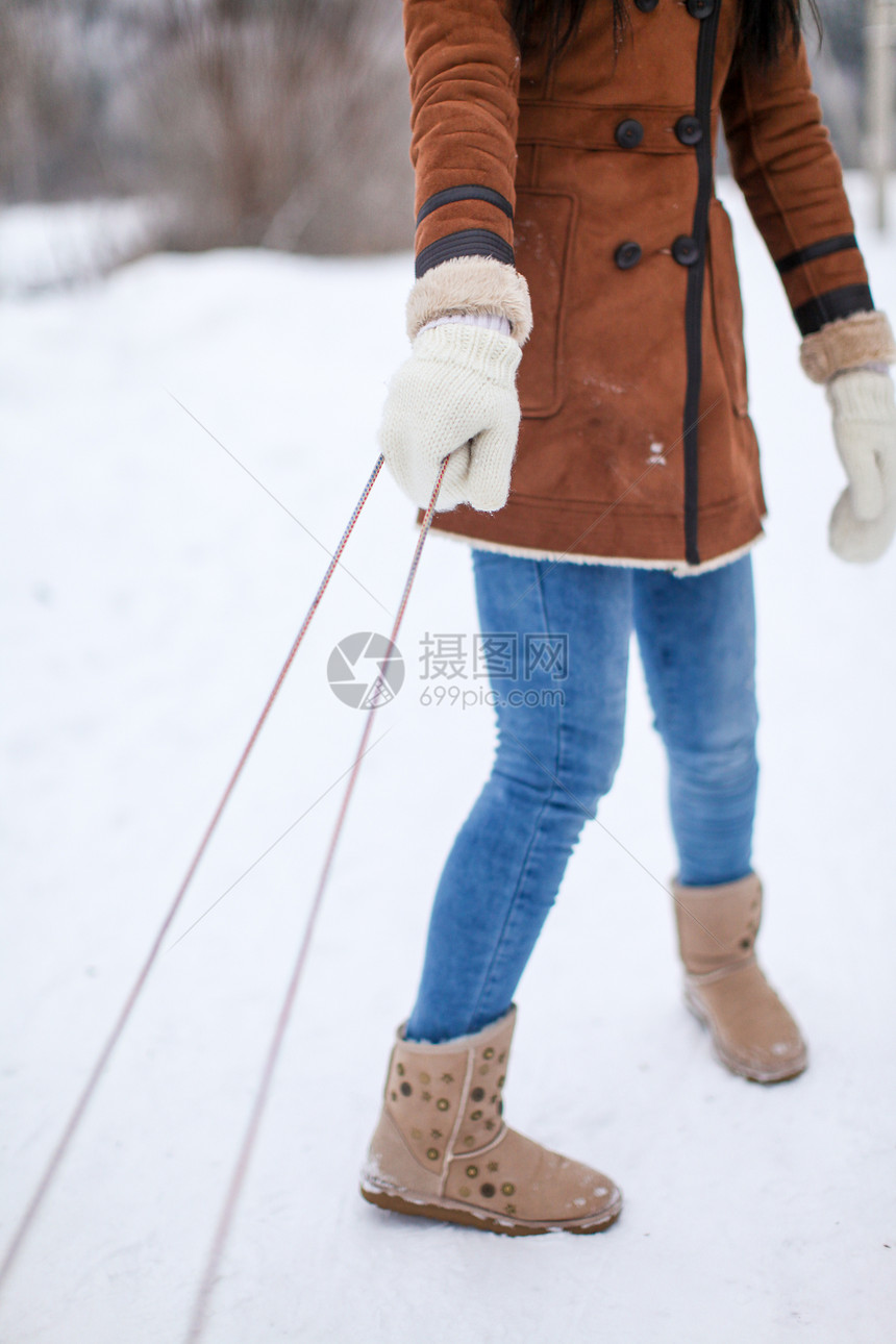 紧紧女性手放在手套上 用雪橇拉拉拉图片