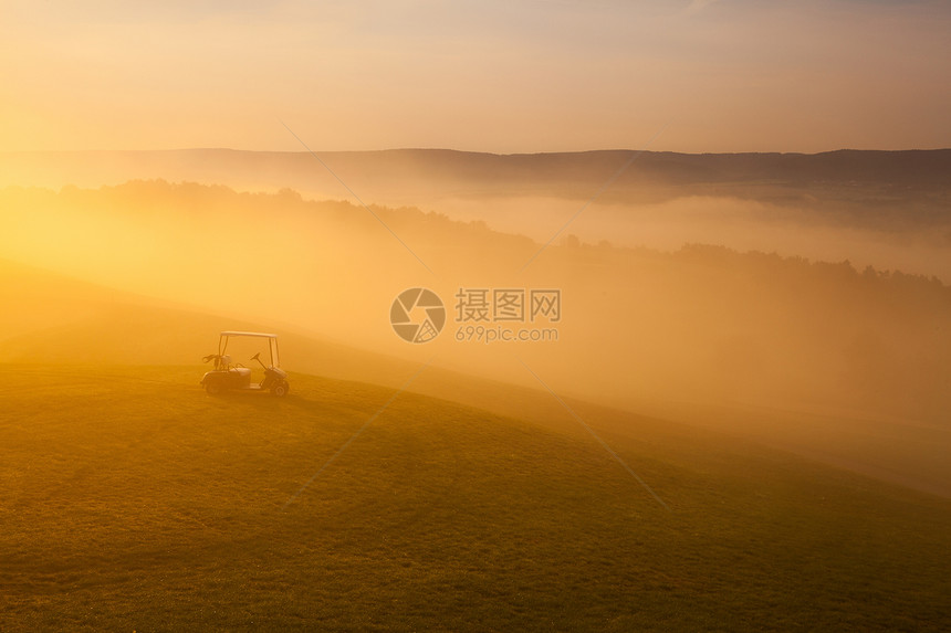 空高尔夫球场上的绿色高尔夫车奢华球座闲暇灌木丛薄雾高尔夫球推杆日落运动竞赛图片