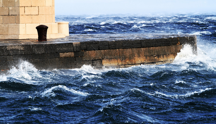 图片代表灯塔 同时吹着强烈的风支撑暴风雨海洋戏剧性蓝色光束海岸危险风景地标图片