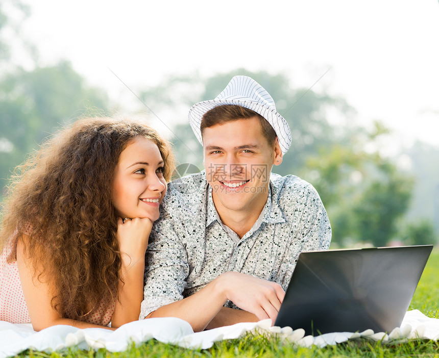 一对夫妇一起躺在公园里 带着笔记本电脑青年喜悦友谊女孩幸福姿势成年人生活技术女性图片