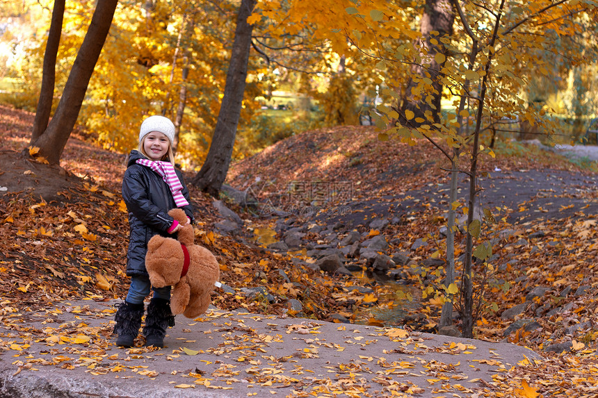 带泰迪熊的可爱女孩乐趣婴儿压痛孩子玩具季节外套树叶晴天投标图片