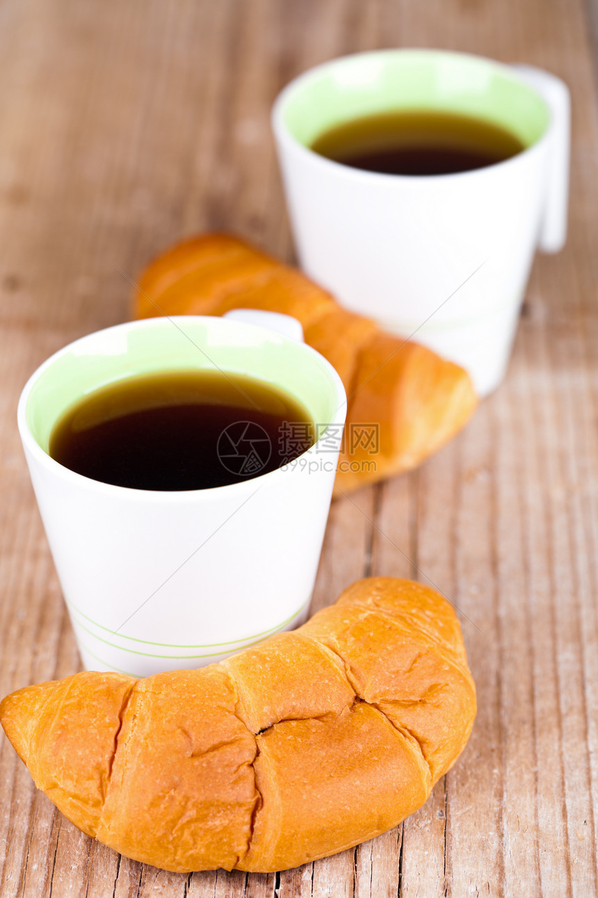 两杯茶和两杯新鲜的羊角面包液体脆皮白色咖啡早餐木头茶点棕色乡村小吃图片