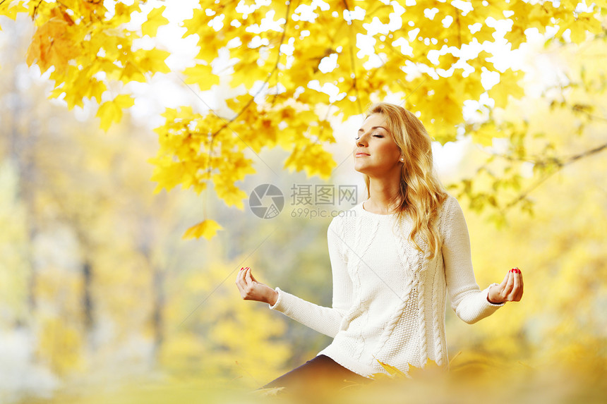 秋天公园的妇女冥想公园叶子娱乐黄色森林瑜伽女士女性女孩图片
