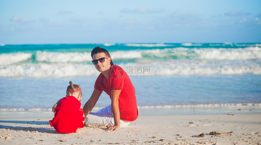 年幼的父亲和他可爱的小女儿 在海滩上玩耍图片