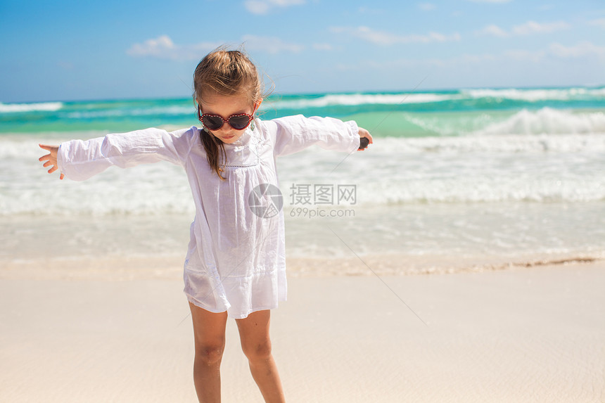 可爱的小女孩在阳光明媚时 在奇异白沙滩上玩得开心旅游热带海岸支撑海洋女孩幸福孩子女性海滩图片