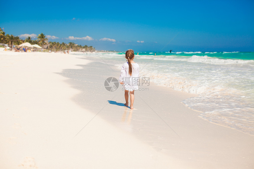 可爱的小女孩在阳光明媚的日子 在奇异白沙滩上奔跑图片