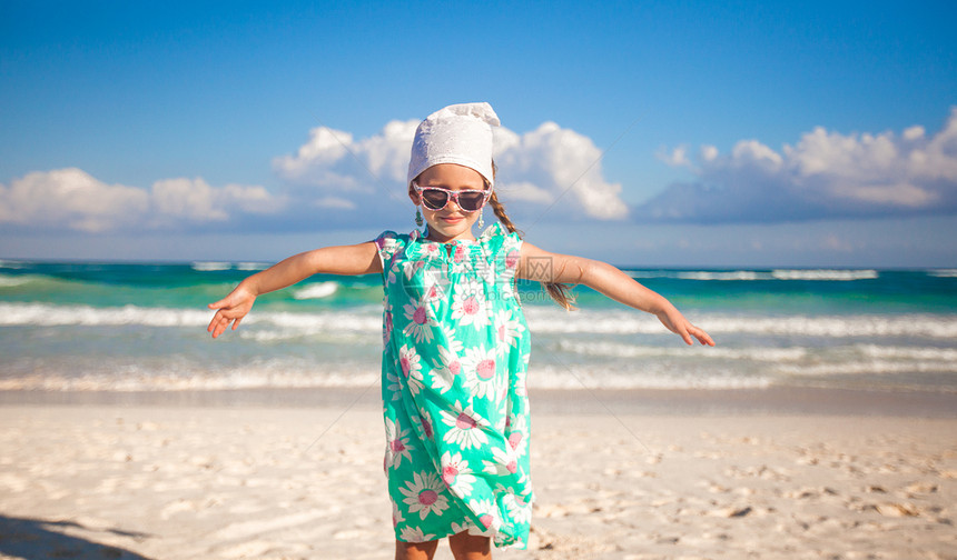 可爱的小女孩在阳光明媚时 在奇异白沙滩上玩得开心乐趣女性假期海滩幸福自由婴儿海岸异国旅游图片