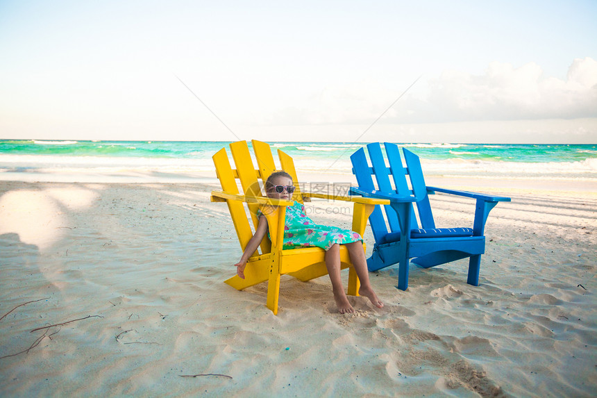 墨西哥Tulum热带海滩上沙滩木制多彩椅子上的小女孩太阳海洋休息室情调风景闲暇海岸线海景异国海岸图片