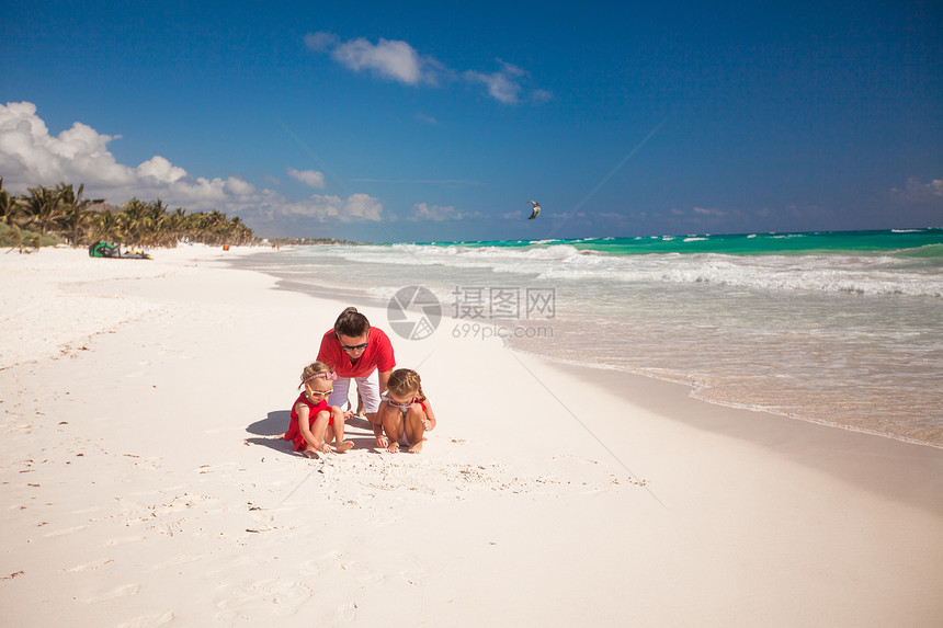 父亲和他的可爱女儿们 在海滩上玩耍 在沙滩上玩男人团聚女孩幸福情调海岸家庭乐趣男性假期图片