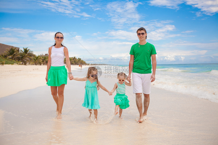 四口的年轻美丽家庭 享受沙滩上放松的快乐旅游女孩女士乐趣孩子孩子们海岸妈妈成人母亲图片
