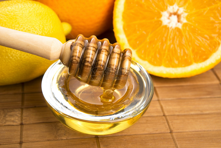 含柠檬和橙子水果的新鲜蜂蜜食物甜点漏勺生活方式美食家甜食健康饮食玻璃金子木头图片