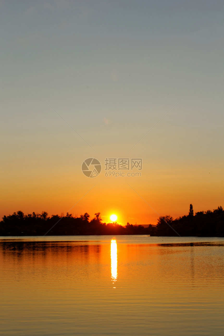 色彩多彩的日落树木地平线蓝色海滩太阳波纹风景天空旅行假期图片