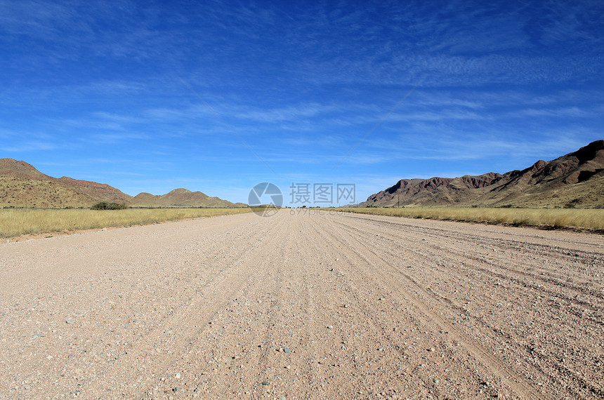 具有山地背景的草草萨凡纳 Namib沙漠路图片