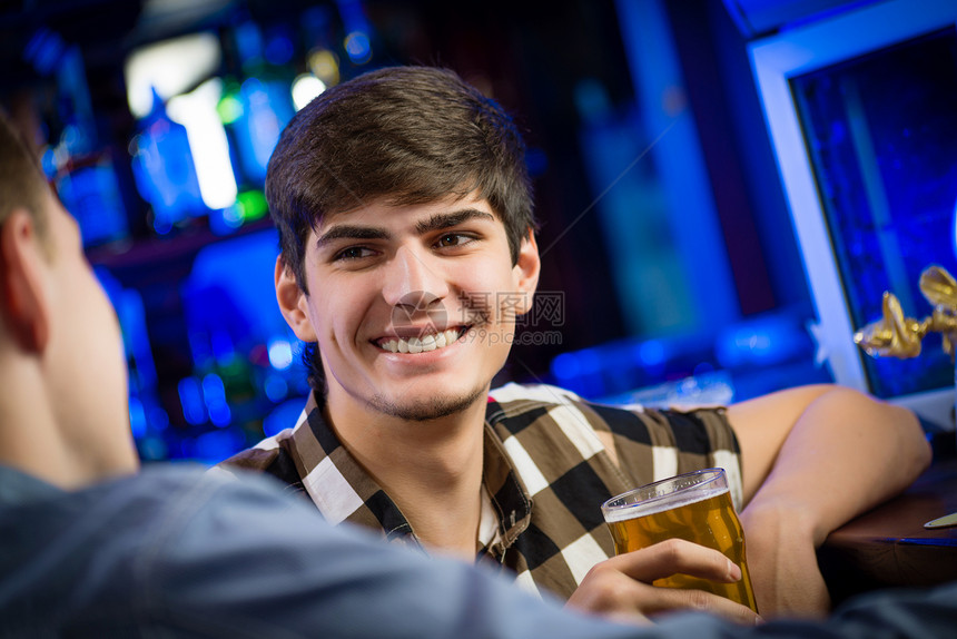 酒吧一位年轻人的肖像朋友们闲暇啤酒男性俱乐部蓝色乐趣玻璃套装成人图片